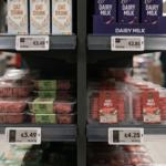 Supermarket shelves displaying plant-based mince and dairy-free milk priced lower than conventional beef mince and dairy milk, highlighting the 2026 price inversion trend.